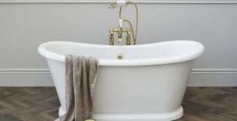 White bathtub with brass fixtures. 